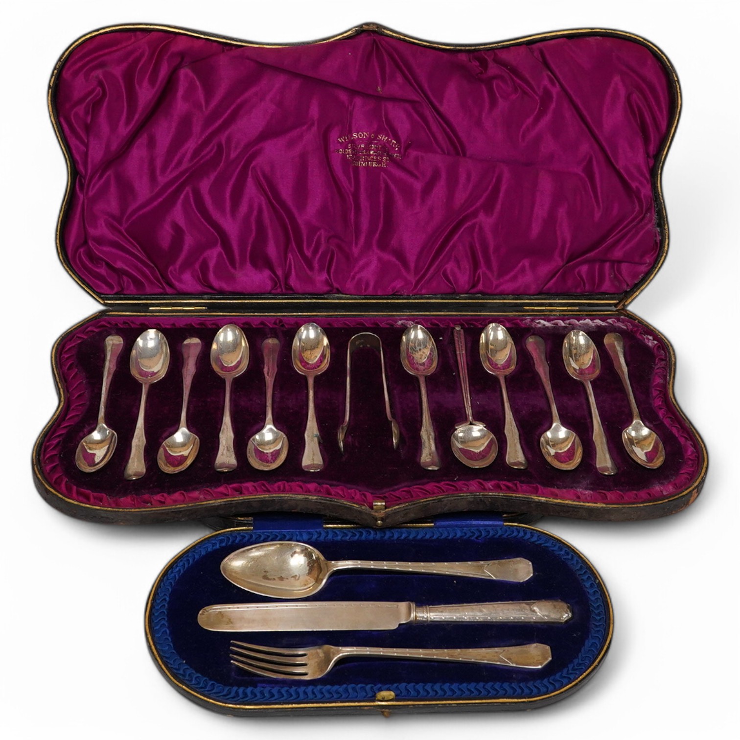 A cased Edwardian silver Christening trio, by Henry Wigful, Sheffield, 1909 and a cased set of eleven Edwardian silver coffee spoons and pair of sugar tongs, London, 1901/2 and one odd silver golf related teaspoon. Condi